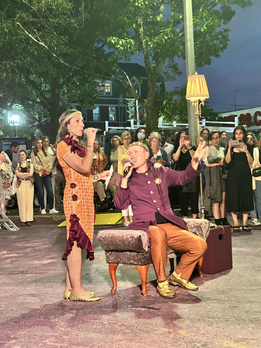 “Claudius (Brooks Reeves) and Gertrude (Paola Ferrer) speak of Hamlet (Armando Rivera) after hearing his live letter to Ophelia (Anna Riggins), as the audience forms a circle around the scene.