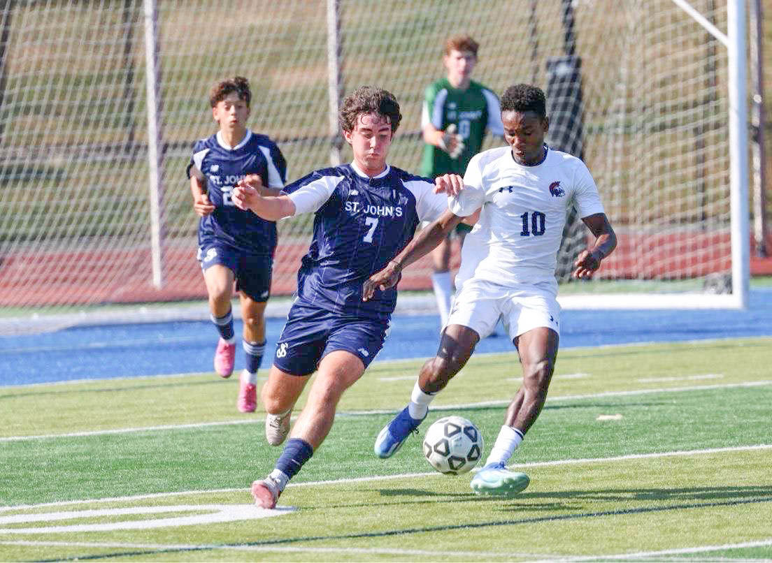 Dorvilier (10) is a forward on the boys varsity soccer team. He applys pressure to the St. John’s Preparatory defenders as they attempt to play the ball out of their half.