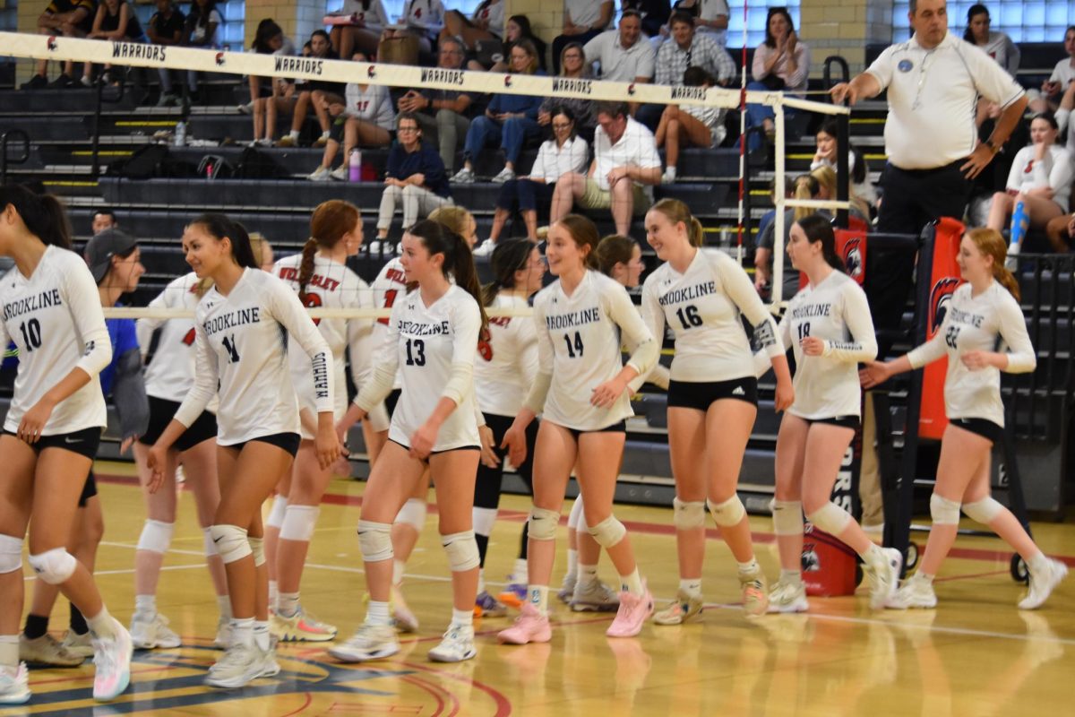 The girls varsity volleyball team high fives the Wellesley Raiders after a win at home on Tuesday, Sept. 10. 