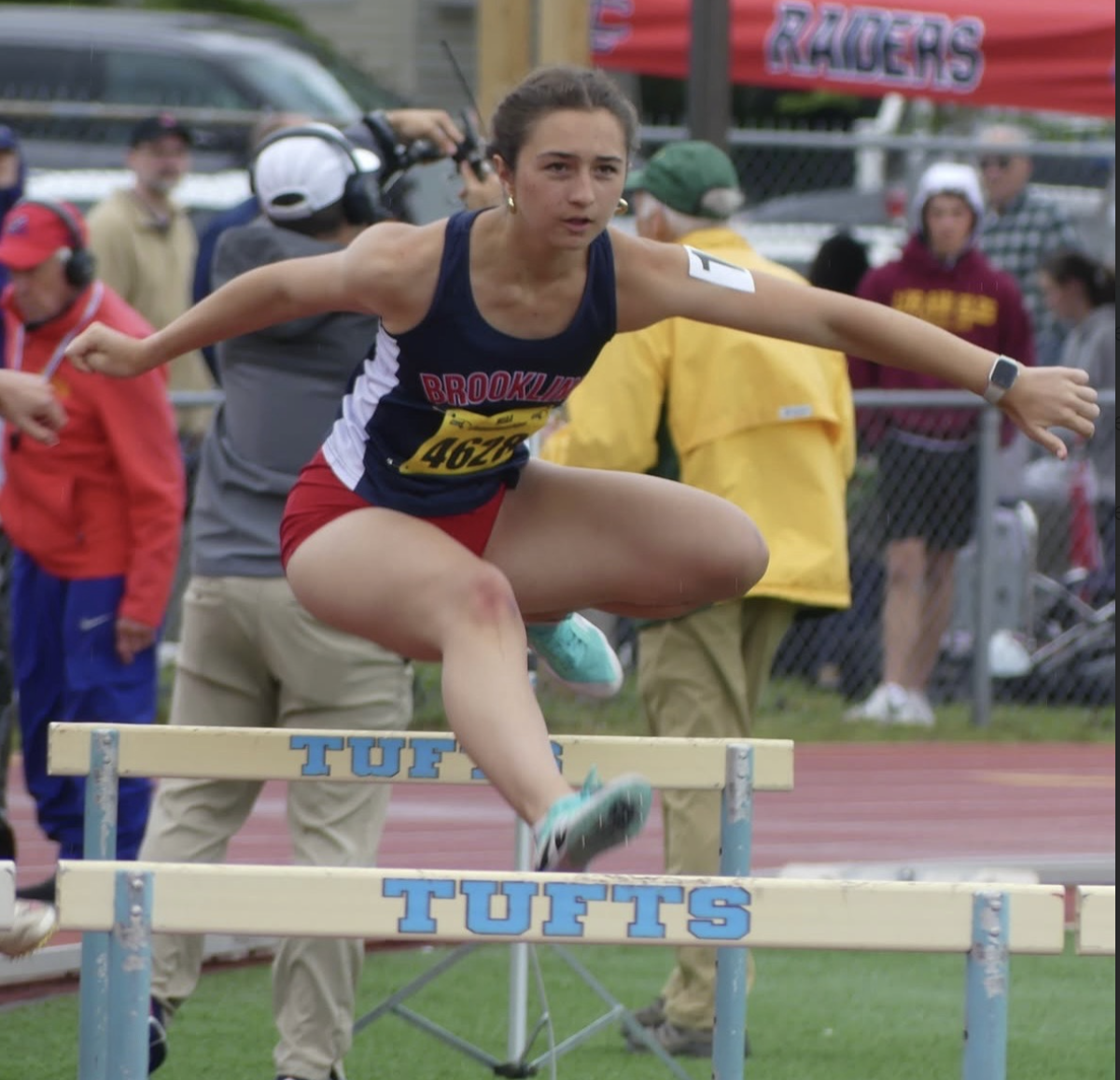 Kalina Ivanov jumps over a hurdle at a track meet taking place at Tufts University. Ivanov will continue her track career at Haverford College.